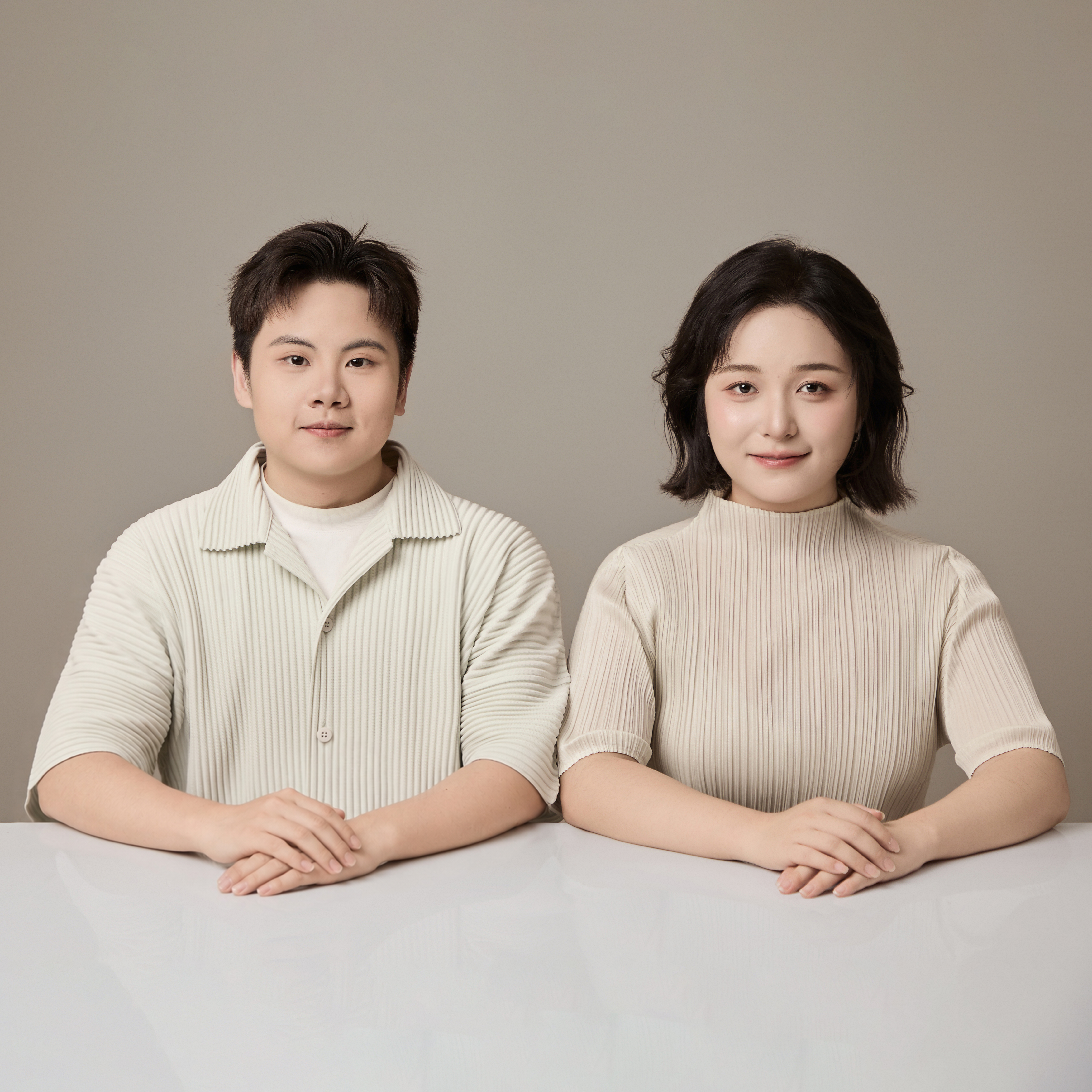 The two founders of Futari Design, seated together.